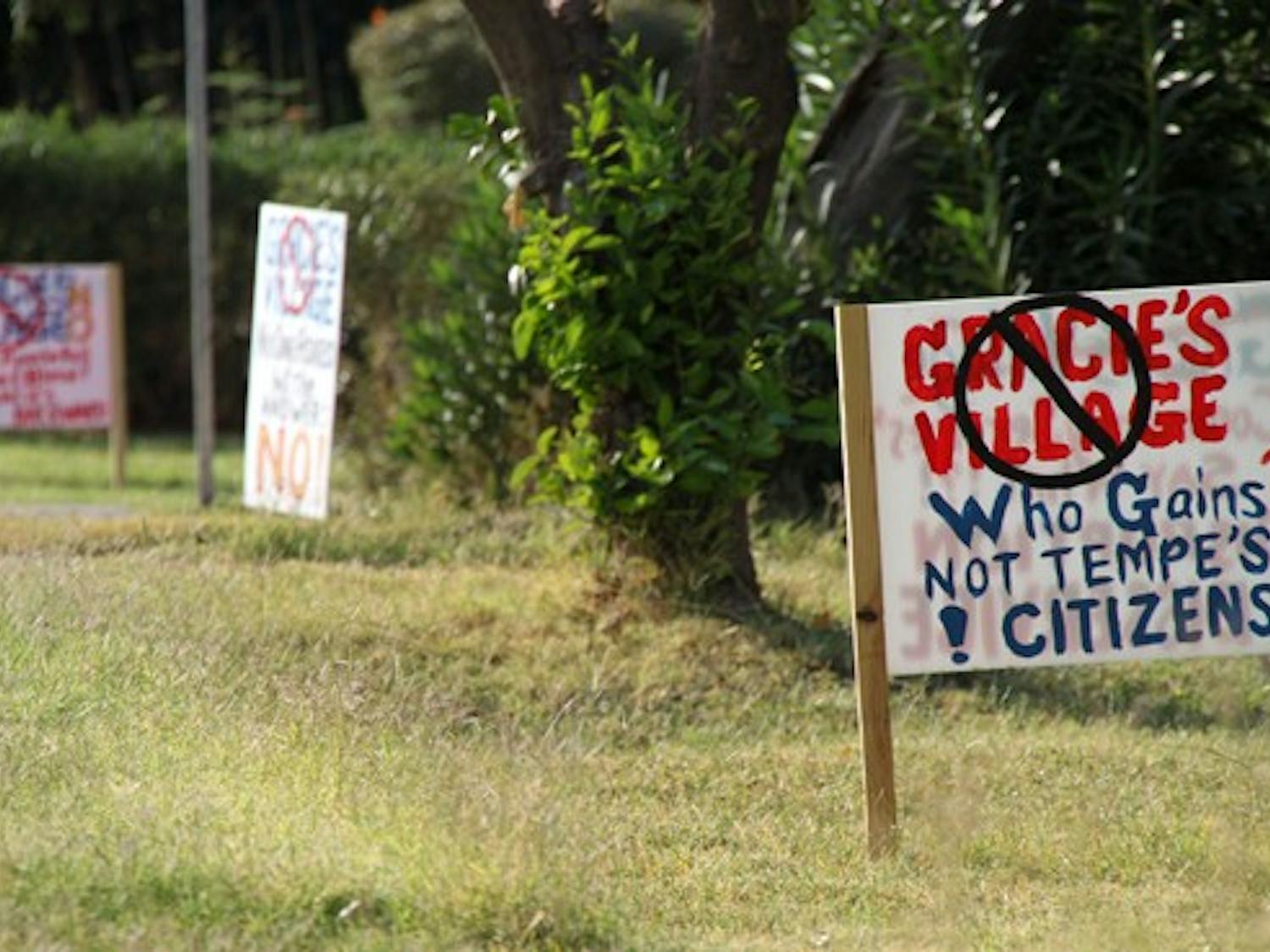 NOT HAPPY: Neighbors of Gracie’s thrift store express their opposition to the proposed building plans with scattered yard signs. (Photo by Rosie Gochnour)