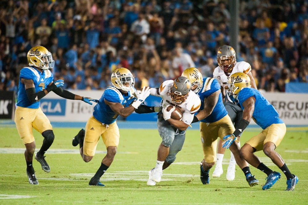 Sophomore running back Demario Richard (4) tries to escape UCLA tacklers on Saturday, Oct. 3, 2015, at Rose Bowl Stadium in Pasadena, Calif. The Sun Devils defeated the Bruins 38-23.