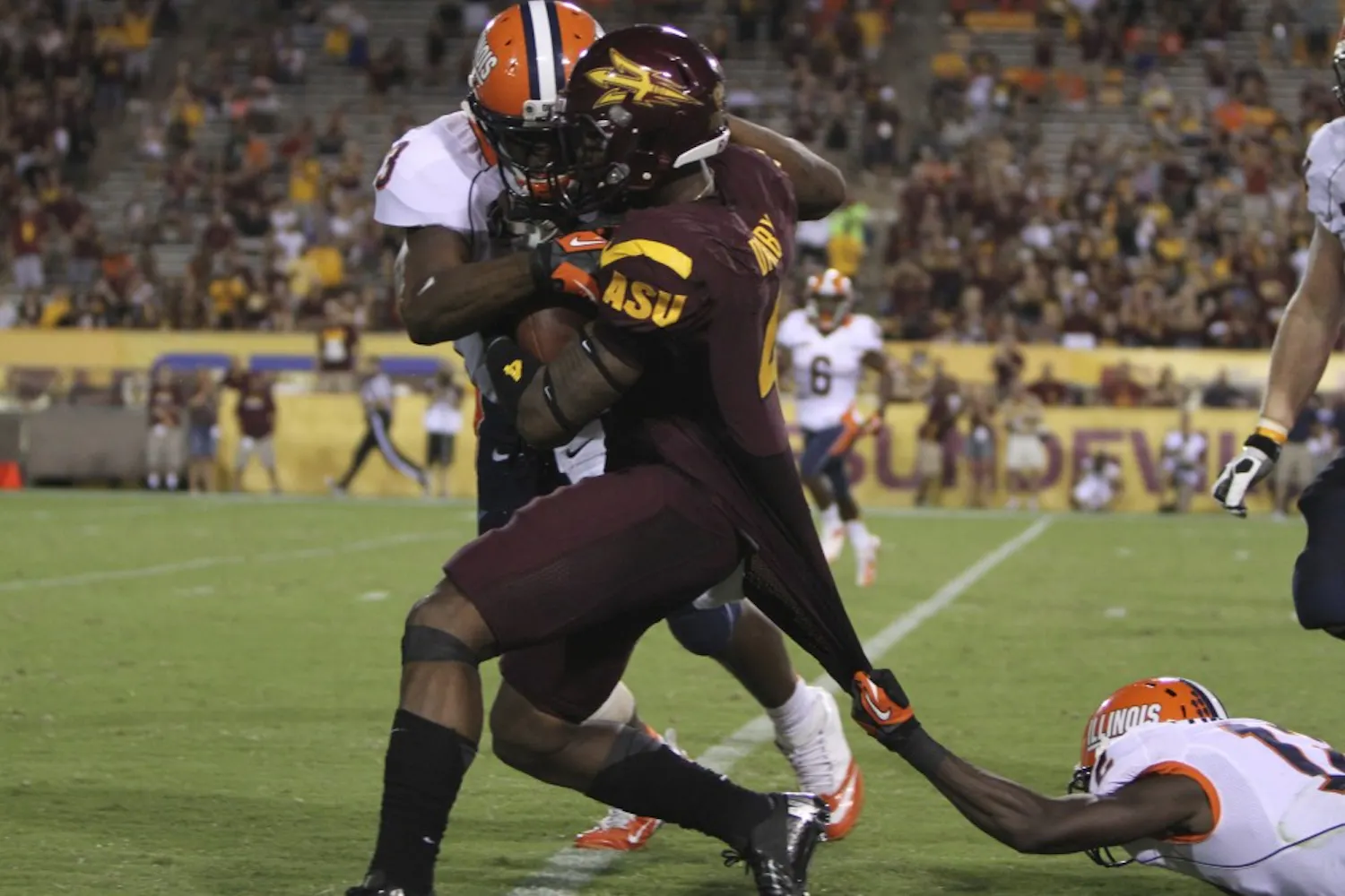 Junior safety Alden Darby gets stopped by two Illinois tacklers after catching an interception during the Sun Devils’ 45-14 win over the Illini on Sept. 8. (Photo by Sam Rosenbaum)