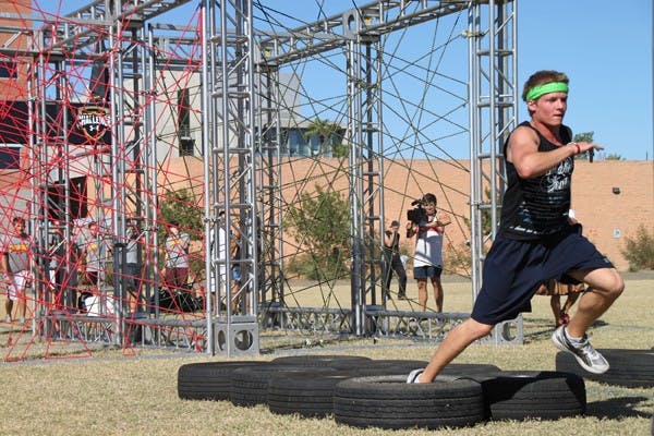 MAD DASH: Sophomore English education major Kyle Rezzarday sprints through tires at the Under Armour 2011 Challenge on the Tempe campus Thursday afternoon.  The obstacle course was put on by the ASU bookstores and featured Lil Jon as a DJ for the event. (Photo by Rosie Gochnour)