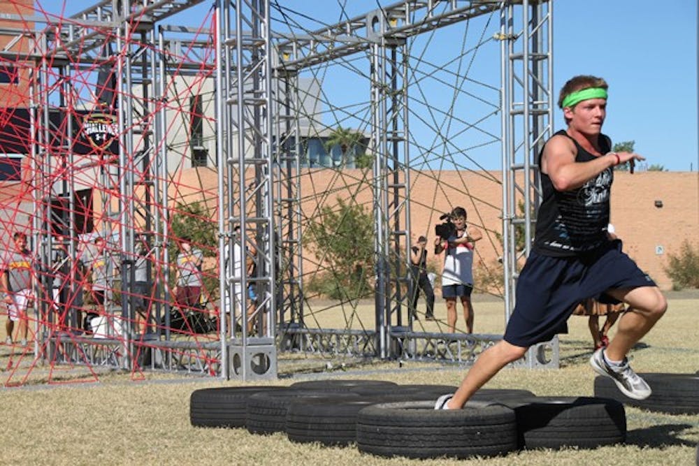 MAD DASH: Sophomore English education major Kyle Rezzarday sprints through tires at the Under Armour 2011 Challenge on the Tempe campus Thursday afternoon.  The obstacle course was put on by the ASU bookstores and featured Lil Jon as a DJ for the event. (Photo by Rosie Gochnour)