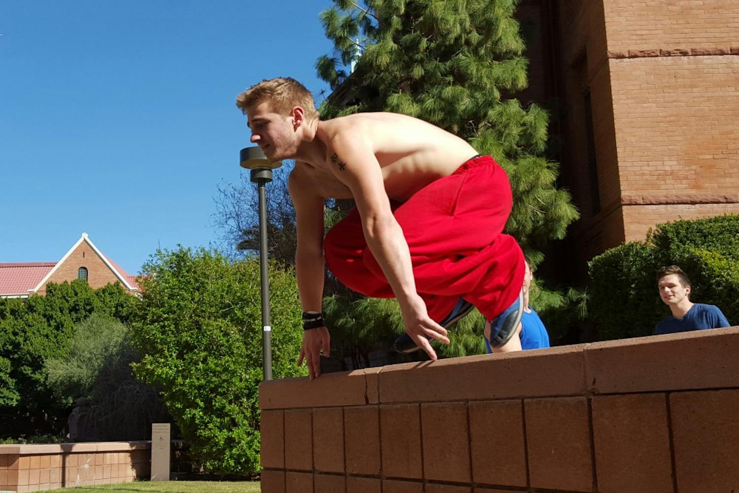 Parkour at Arizona State president Eric Klein vaults a wall outside of Old Main at their practice on Saturday, Feb. 27, 2016, on the Tempe campus.