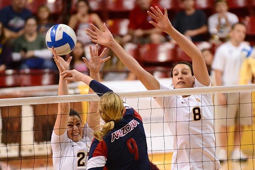 Allison Palmer (left) and Whitney Follette block a spike from UA's Madi Kingdon.