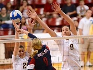 Allison Palmer (left) and Whitney Follette block a spike from UA's Madi Kingdon.
