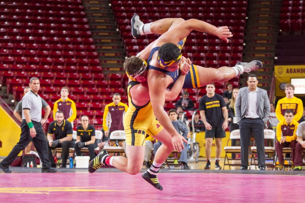 Freshman Tanner Hall lifts WVU Senior A.J. Vizcarrondo and slams him to the mat in the final moments of the match to end the morning meet on Saturday, Jan. 23, 2016 at the Wells Fargo Arena in Tempe. The Sun Devils won in a final match decision.