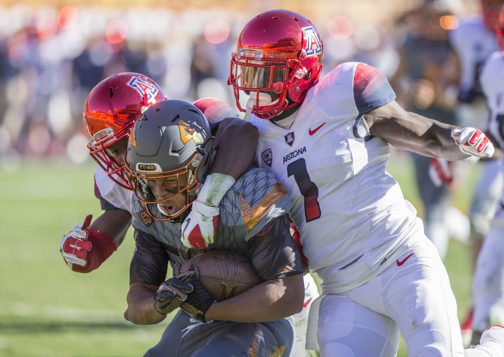 Sophomore running back Demario Richard is tackled by UA defenders during a game at Sun Devil Stadium in Tempe, Ariz., on Saturday, Nov. 21, 2015. The ASU Sun Devils led the UA Wildcats 31-10 at halftime. 