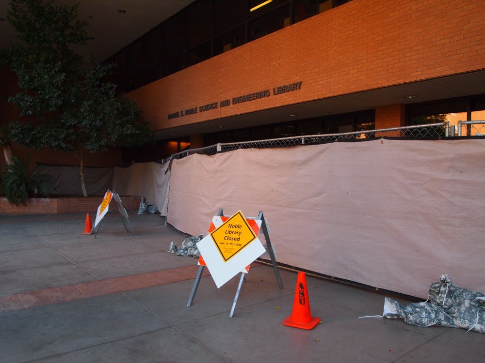 Closed signs sit in front of the Noble Library on March 17, 2015, alerting any passerby that it has been closed due to flooding. (Kaitlyn Ahrbeck/ The State Press)