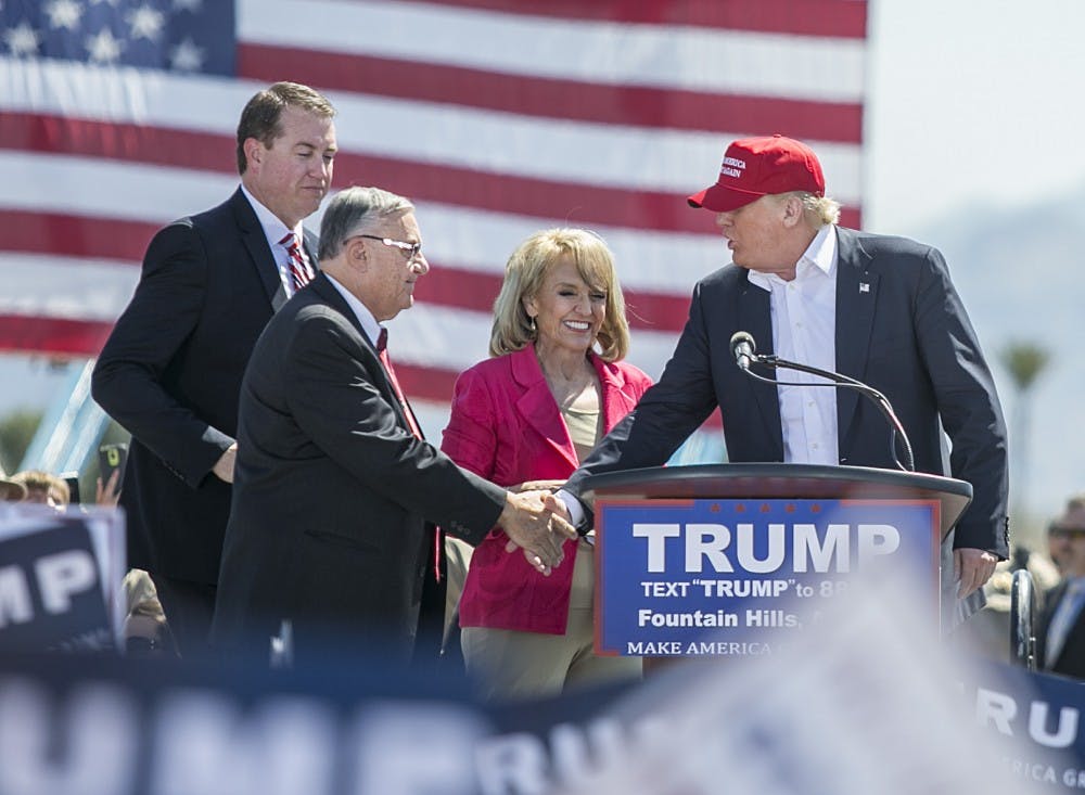 State Treasurer Jeff DeWitt, left, is joined by Maricopa County Sheriff Joe Arpaio and former Arizona Gov. Jan Brewer, right, while introducing presidential candidate Donald Trump, right, during his rally at Fountain Park in Fountain Hills, Arizona, on Saturday, March 19, 2016. 