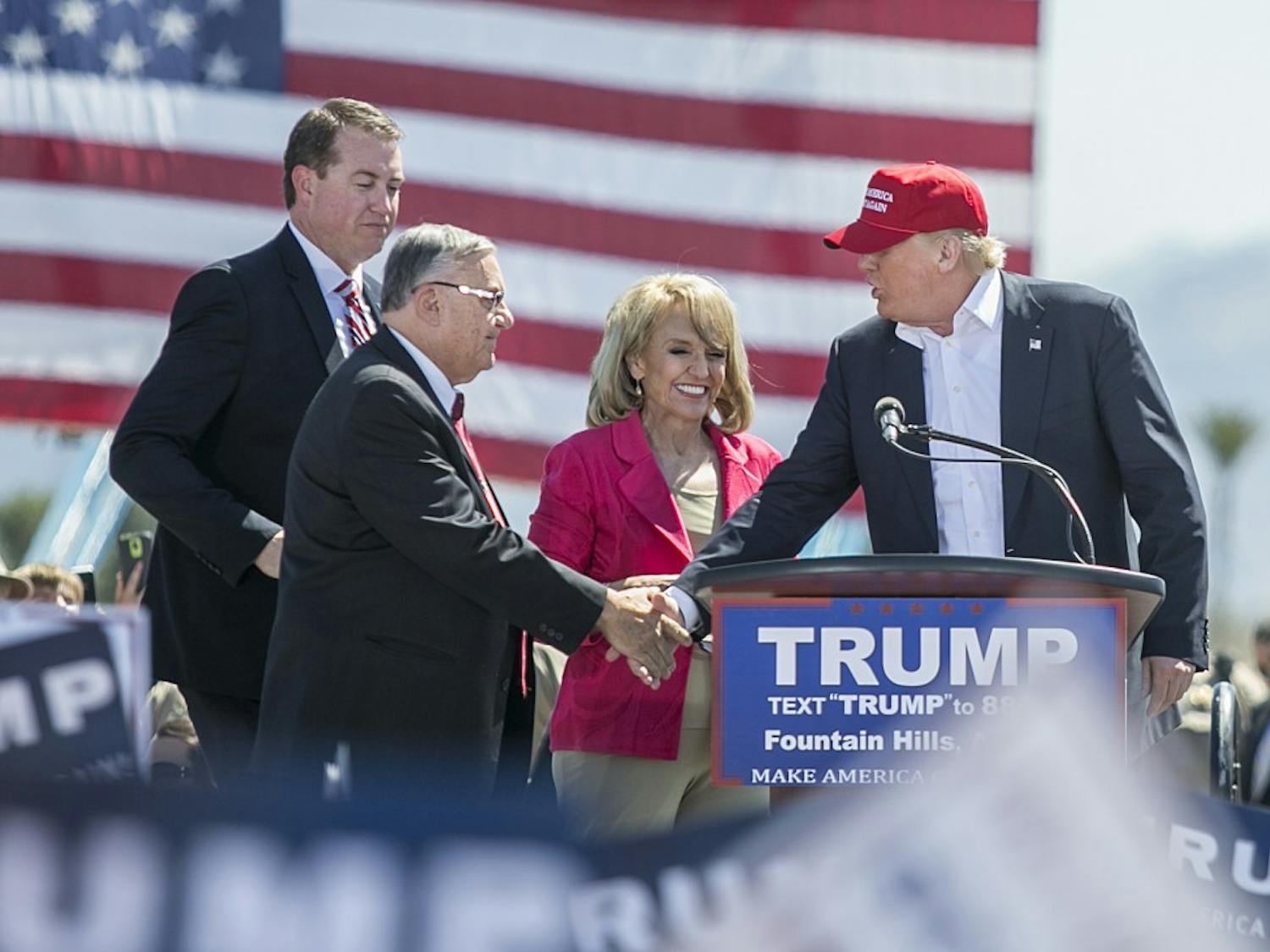 State Treasurer Jeff DeWitt, left, is joined by Maricopa County Sheriff Joe Arpaio and former Arizona Gov. Jan Brewer, right, while introducing presidential candidate Donald Trump, right, during his rally at Fountain Park in Fountain Hills, Arizona, on Saturday, March 19, 2016. 