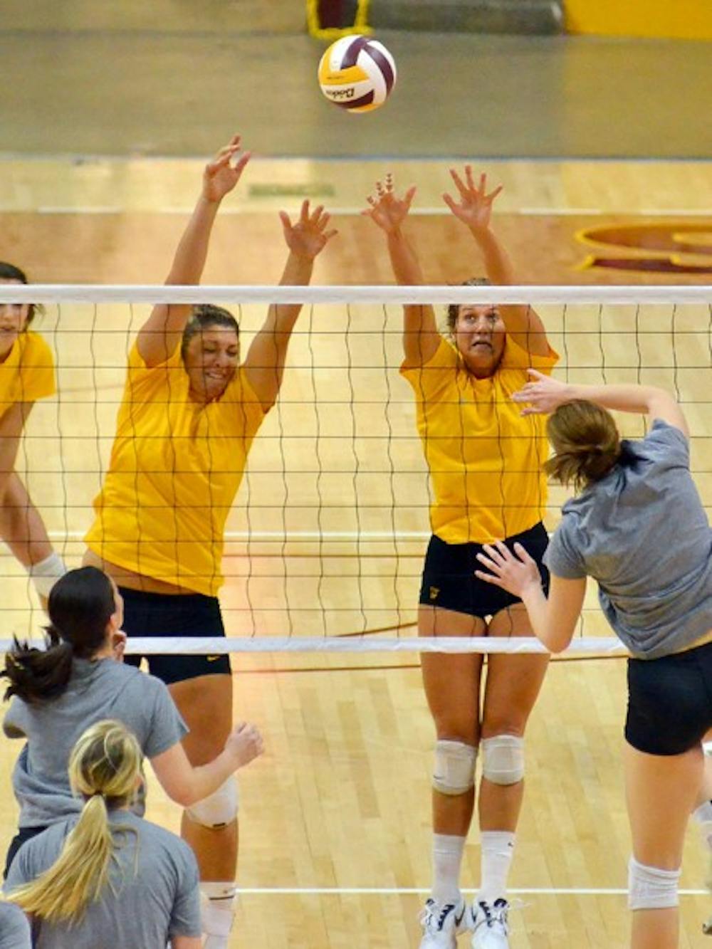 BUILDING BLOCKS: ASU senior middle blocker Sonja Markanovich and redshirt sophomore outside hitter Ashley Kastl raise up to block a shot in the Alumnae Match last August. The team centers on their unofficial motto, “One and Done,” to encourage themselves during games. (Photo by Aaron Lavinsky)