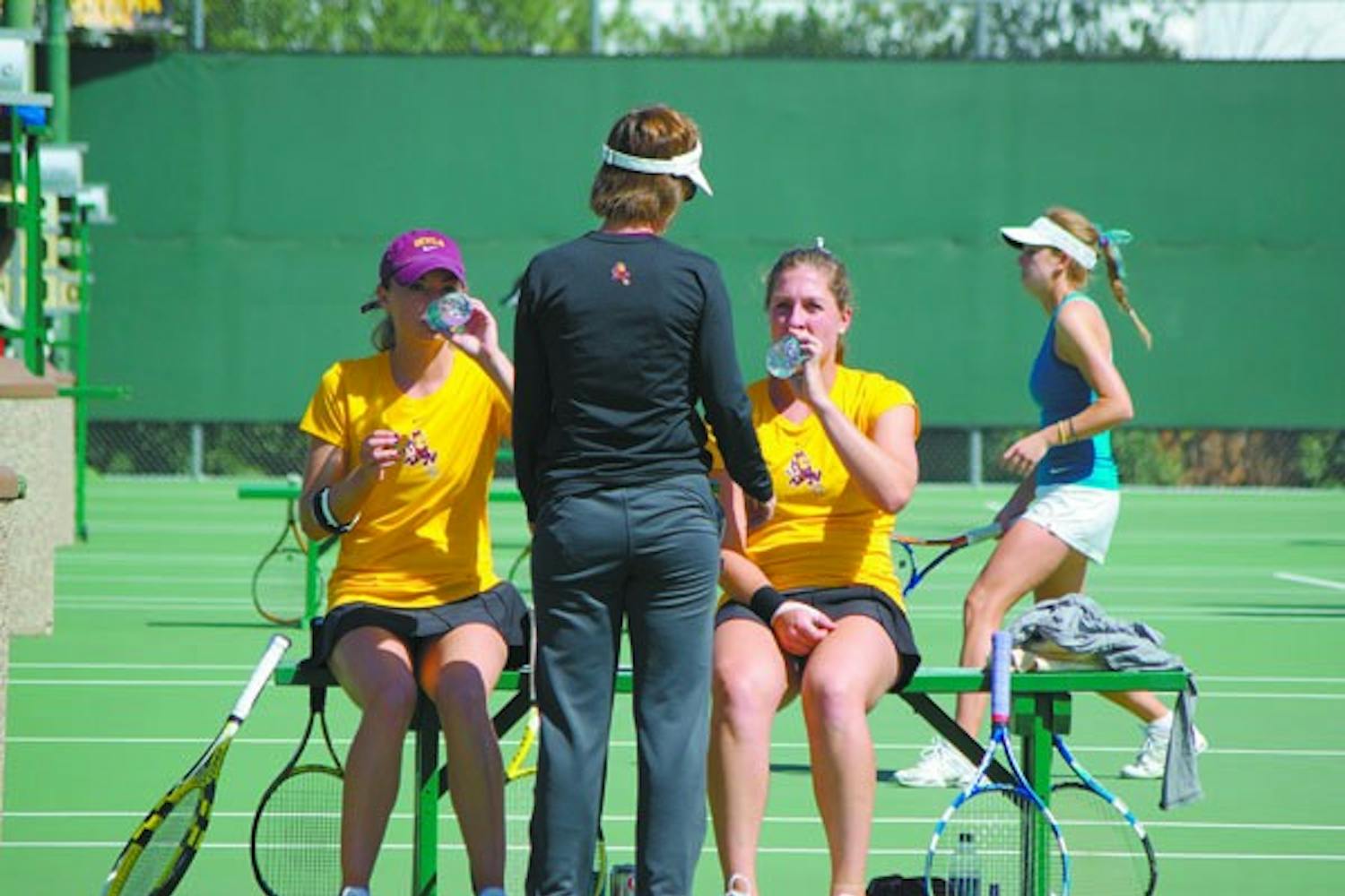 Sweeping up: ASU coach Sheila McInerney talks to seniors Micaela Hein (left) and Kelcy McKenna (right) during a break in their doubles match against UC Irvine on Tuesday. The Sun Devils beat both UC Irvine and DePaul on Wednesday by the same score, 7-0. (Photo by Nathan Meachem)