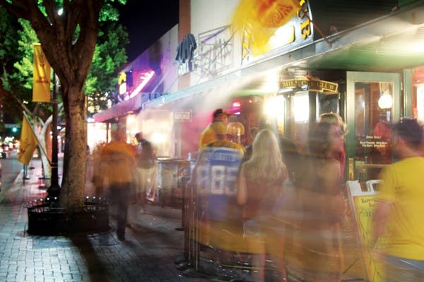 People line up outside Mill Cue Club as others stroll past on a busy Thursday night on Mill Avenue. (Photo by Jenn Allen)
