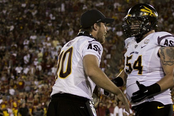 Redshirt senior quarterback Taylor Kelly goes to celebrate with redshirt senior offensive lineman Tyler Sulka after a play in a game against USC on Oct. 4, 2014. ASU won against USC 38-34. (Photo by Alexis Macklin)