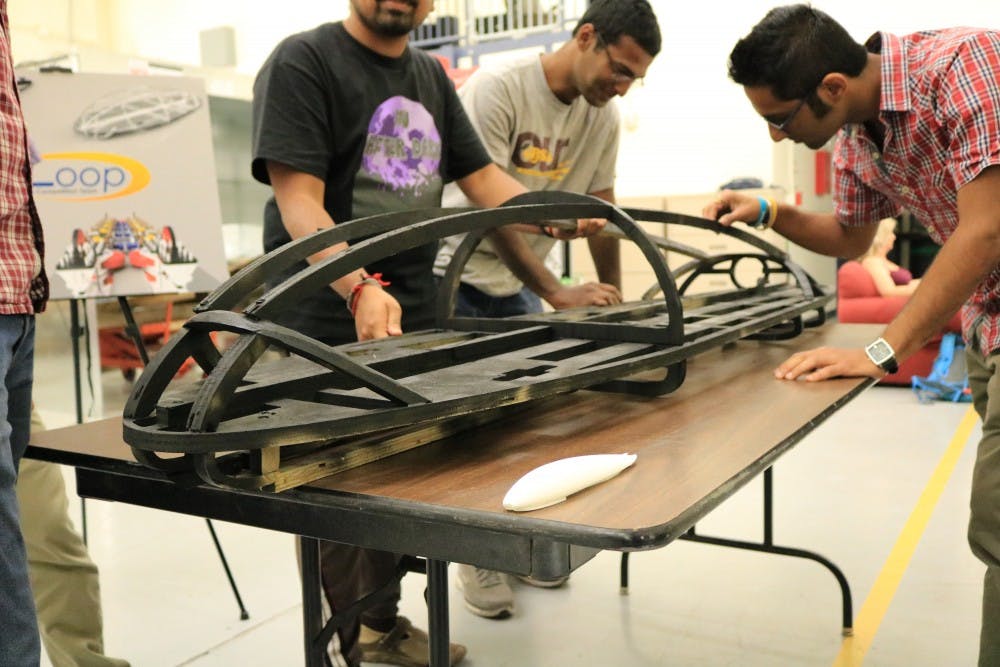 Members of the AZloop manufacturing team work with a display model of the pod at ASU's Polytechnic campus on Friday, April 7, 2017.