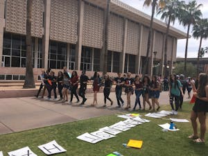 Students gather near Hayden Lawn on ASU's Tempe campus blocking the sidewalk with a human wall "against hate” on Thursday, April 13, 2017.
