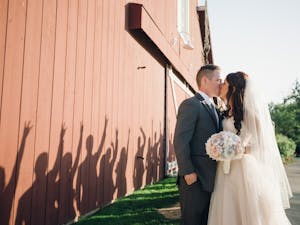 The wedding party gives their best "forks up" while the couple shares a kiss.