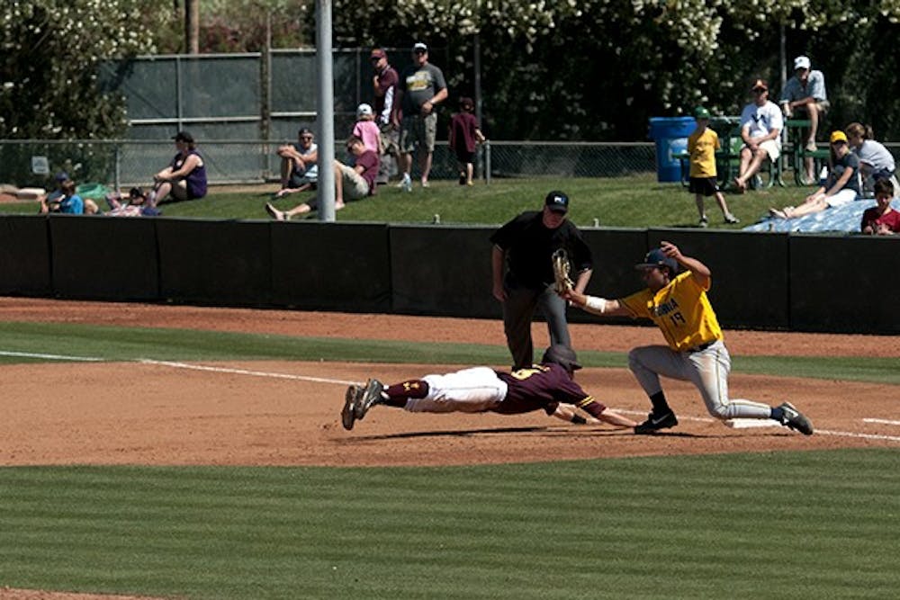 Sophomore infielder Dalton DiNatale slides safely into first after an attempted pick off move. ASU played California on April 13, 2014. (Photo by Mario Mendez)