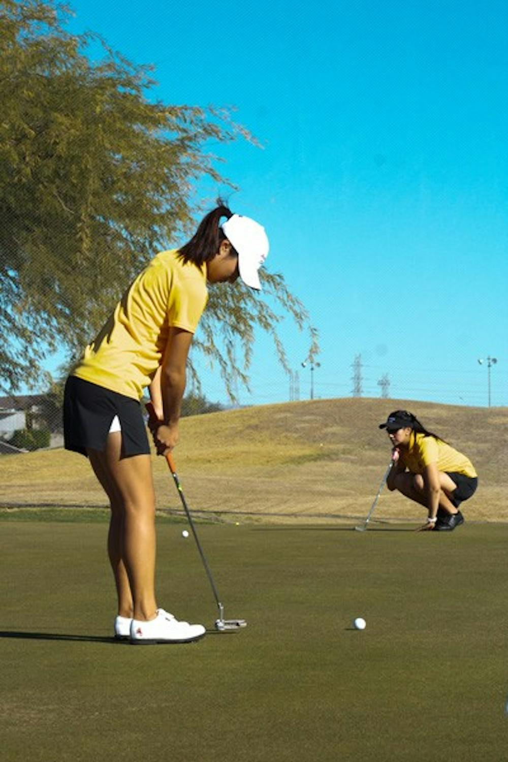 LINING UP: Freshman Justine Lee takes time to perfect her putting before teeing off at ASU Karsten for a practice round. (Photo by Lisa Bartoli)