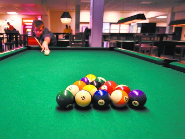 CUE UP: ASU sophomore Thomas Wheeler aims up his shot just before breaking apart the pool balls in Sparky's Den Tuesday afternoon. (Photo by Aaron Lavinsky)