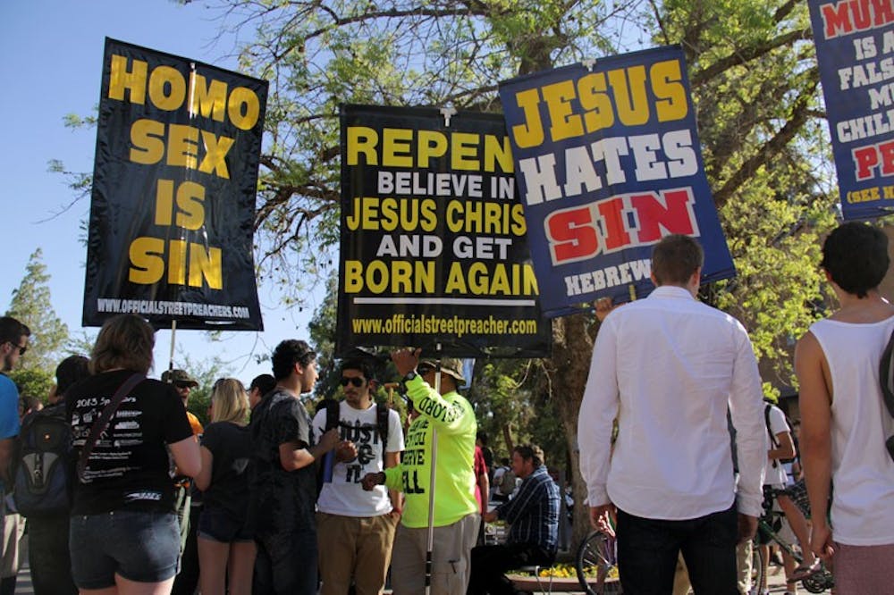 Serveral members of the Bible Believers Street Preachers organization came to the Tempe campus Friday afternoon wielding signs and wearing t-shirts in protest of the Muslim religion and homosexuality. (Photo by Shawn Raymundo)