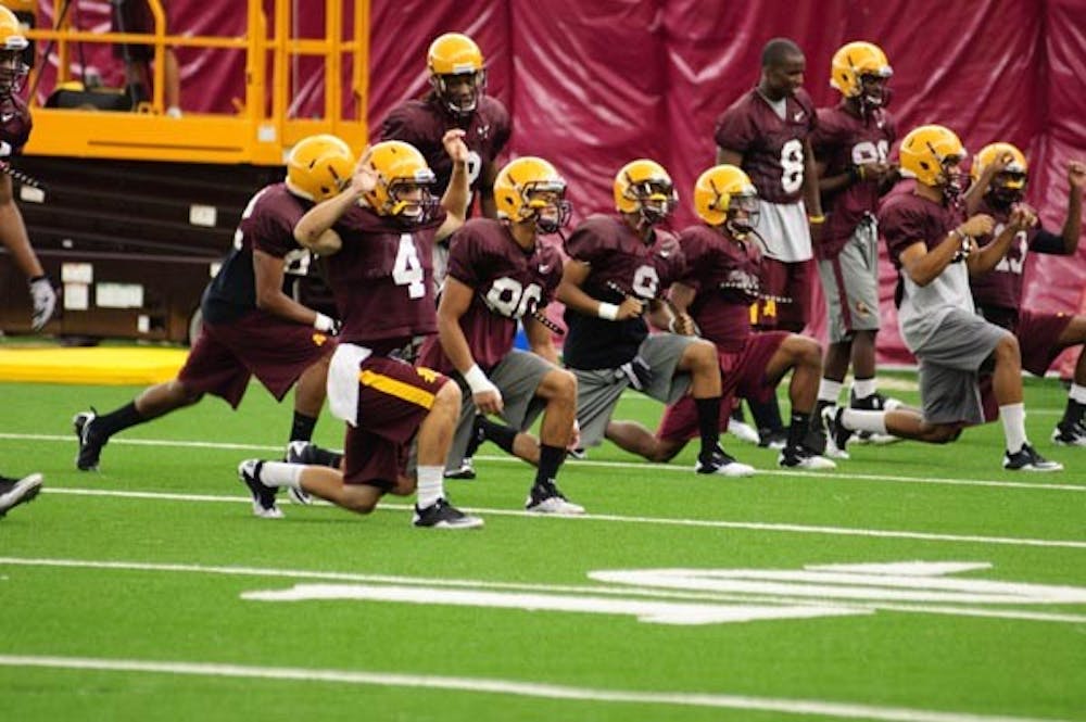 HIGH SPEED: Receivers redshirt junior Aaron Pflugrad (4), redshirt freshman J.J. Holiday (80) and redshirt sophomore A.J. Pickens (9) stretch before Tuesday's practice. The receivers will be key pieces in the team's new fast-paced offensive machine. (Photo by Aaron Lavinsky)