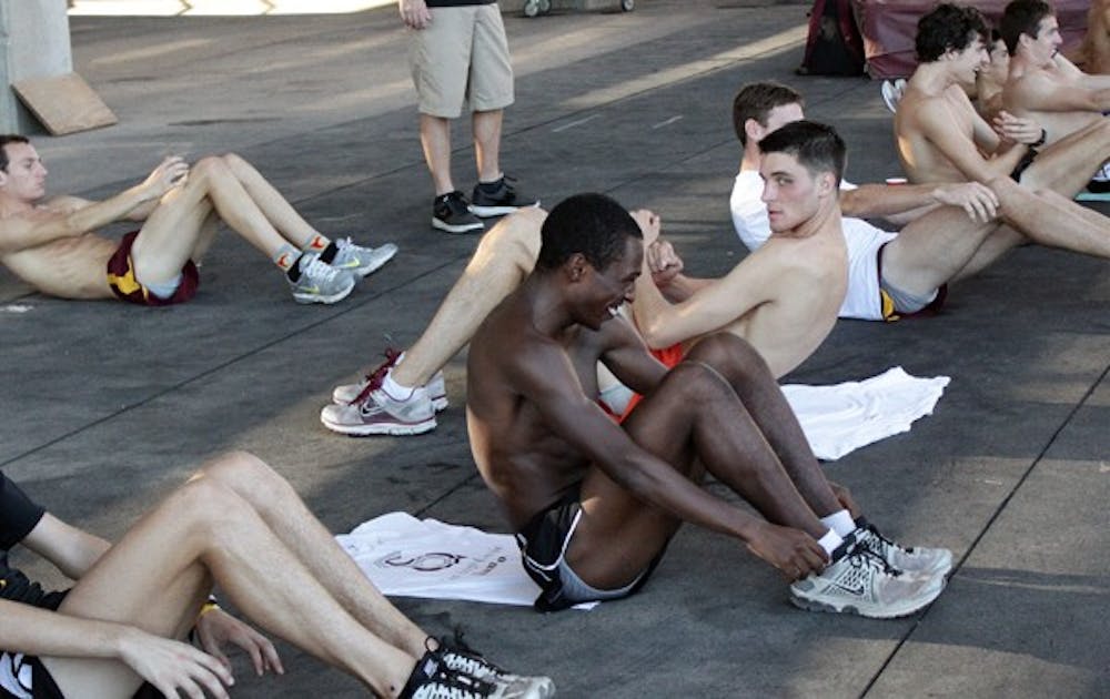 CENTER OF ATTENTION: Redshirt junior Darius Terry laughs with his teammates while the men’s cross-country team works on abs during a practice. ASU cross-country is set to host the first-ever Pac-12 Championships on Saturday at the Wigwam Golf Course. (Photo by Beth Easterbrook)