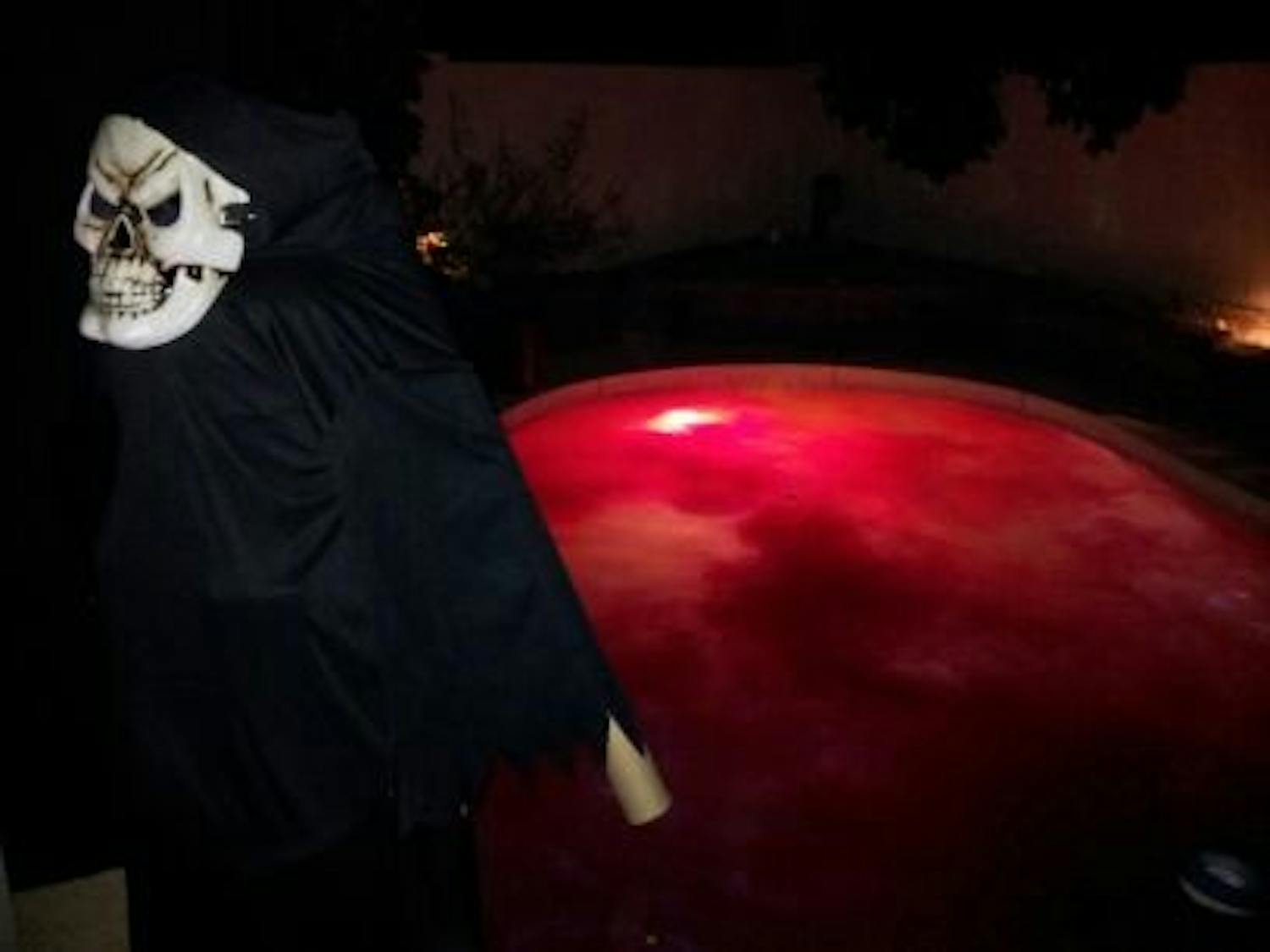 A person dressed as a menacing skeleton stands in front of Laura Jackson's red-dyed swimming pool at her haunted house in Tempe. (Photo courtesy of Laura Jackson)