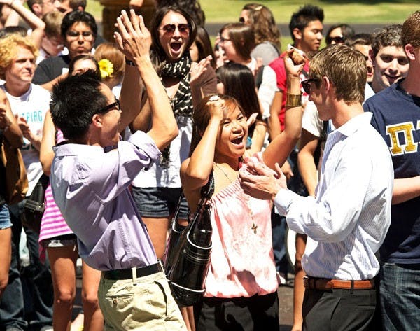 ELECTION RESULTS: Michael Wong, from left, Tina Mounlavongsy and Jacob Goulding celebrate the results of the USG presidential elections, presented at noon on the steps of Old Main. Team Goulding and Team Brendan Corrigan are headed to a runoff election to be held April 13, and the tickets from Athena Salman and Sharvil Kapadia failed to garner enough votes. (Photo by Michael Arellano)