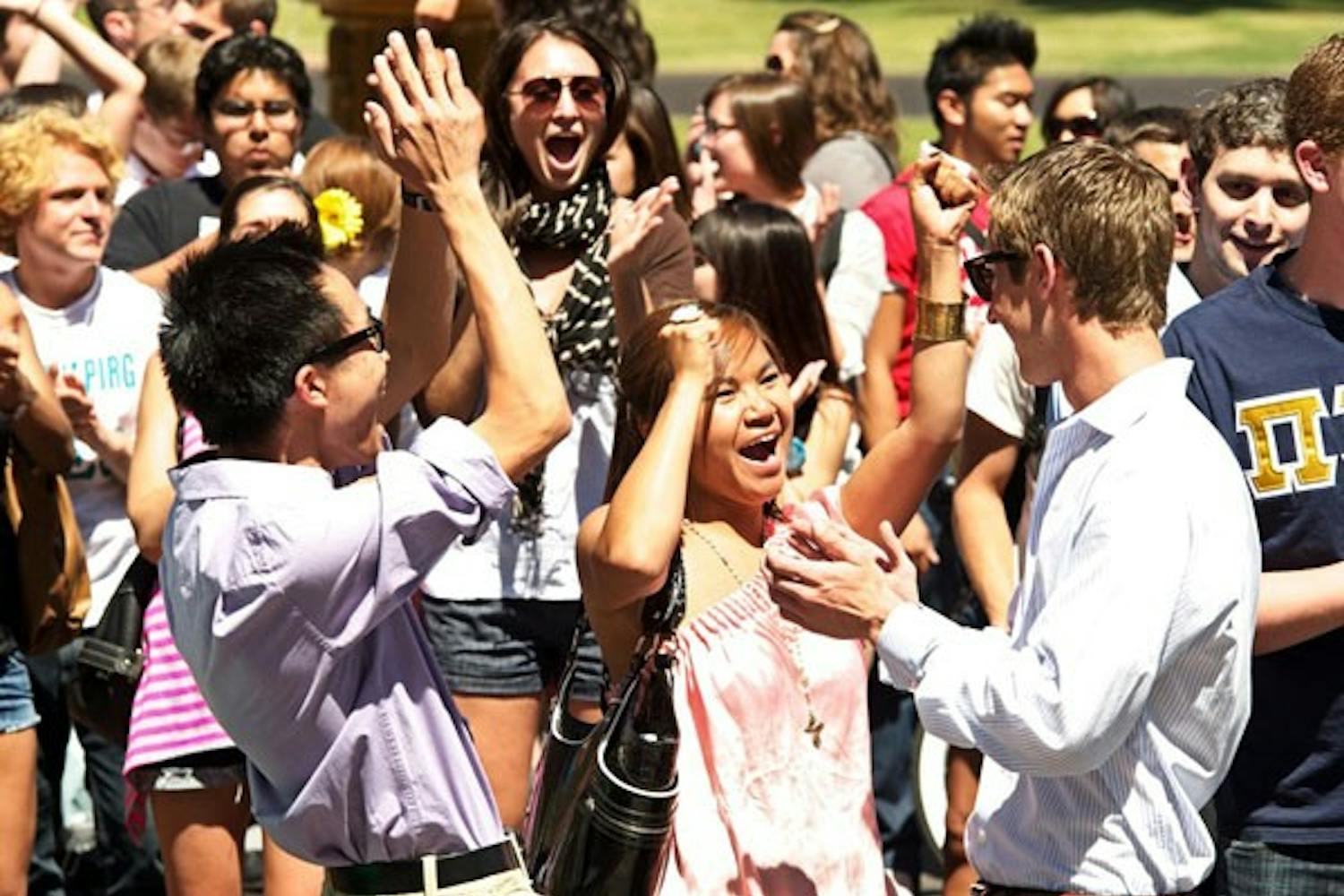 ELECTION RESULTS: Michael Wong, from left, Tina Mounlavongsy and Jacob Goulding celebrate the results of the USG presidential elections, presented at noon on the steps of Old Main. Team Goulding and Team Brendan Corrigan are headed to a runoff election to be held April 13, and the tickets from Athena Salman and Sharvil Kapadia failed to garner enough votes. (Photo by Michael Arellano)