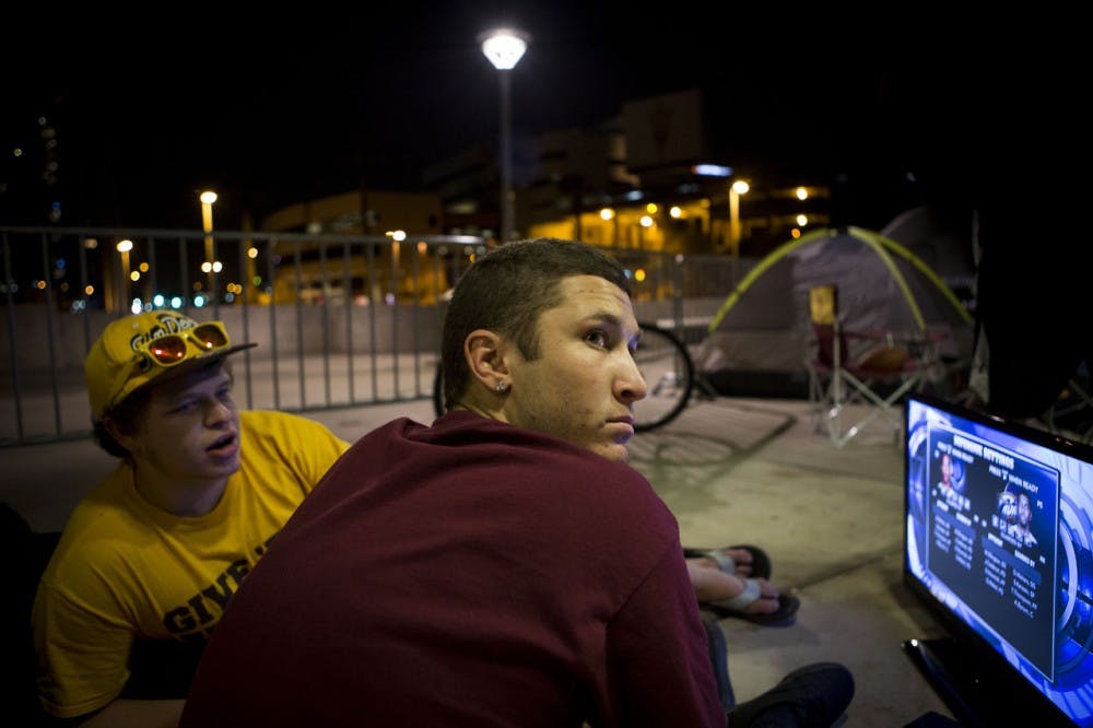 (from left) Business sophomore Trevor Zero and business economics sophomore Christian Portano play video games as they camp out before the Pac-12 Championship Monday, Dec. 2. ASU will face Stanford in the Pac-12 championship game on Saturday, Dec. 7. A select group of hardcore Sun Devil fans have decided to camp outside the stadium for the entire week, leaving their posts only to attend classes. (Photo by Dominic Valente)