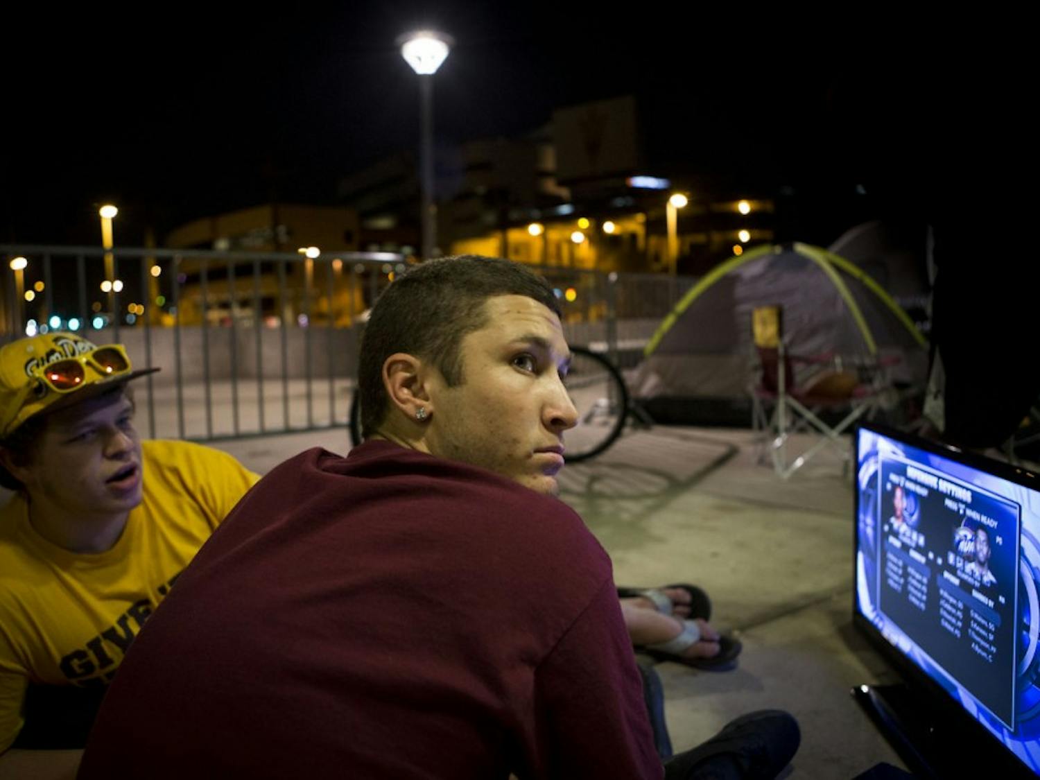 (from left) Business sophomore Trevor Zero and business economics sophomore Christian Portano play video games as they camp out before the Pac-12 Championship Monday, Dec. 2. ASU will face Stanford in the Pac-12 championship game on Saturday, Dec. 7. A select group of hardcore Sun Devil fans have decided to camp outside the stadium for the entire week, leaving their posts only to attend classes. (Photo by Dominic Valente)