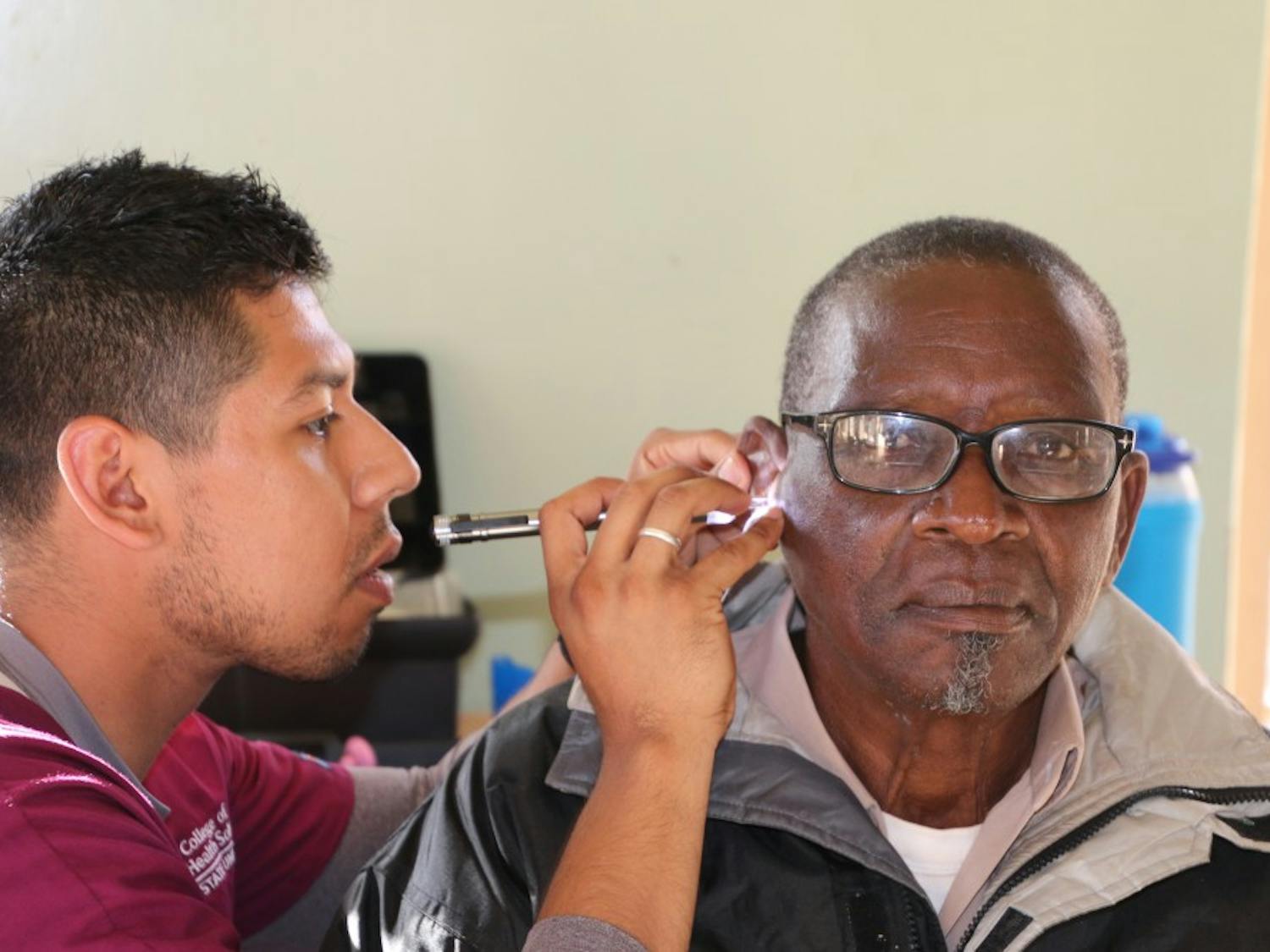 An ASU student from Hearing for Humanity checks the ears of a patient in Malawi during last year's trip.&nbsp;