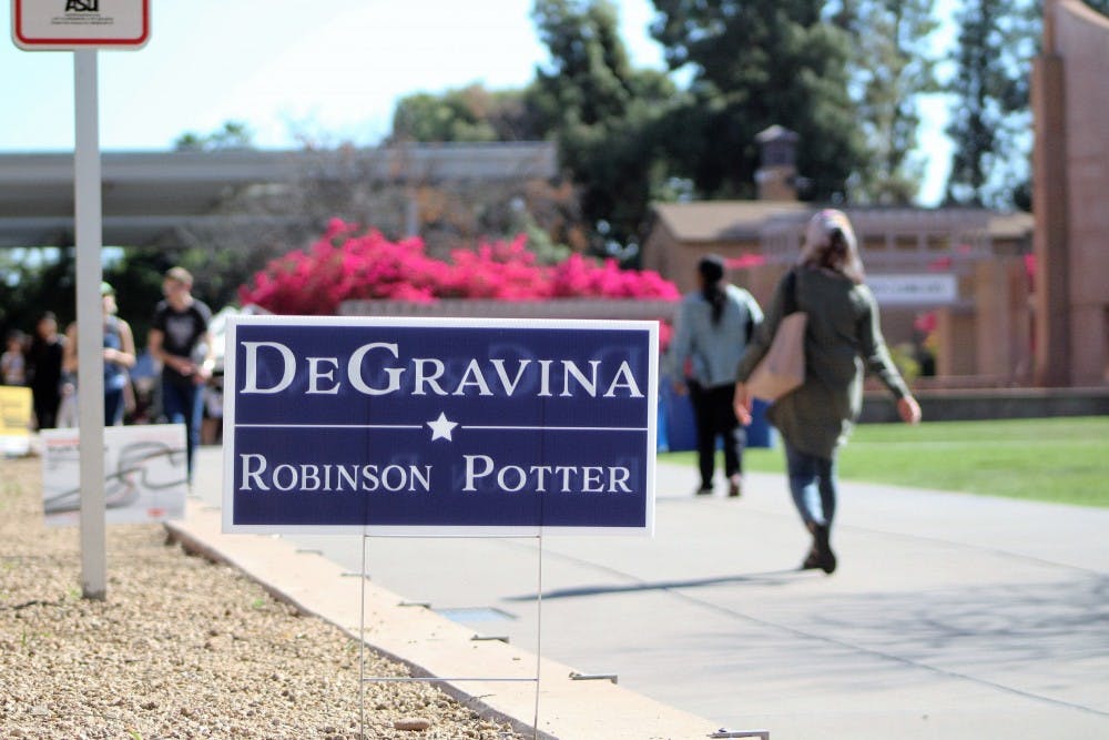 Students walk past a DeGravina campaign sign next to Hayden Lawn on the Tempe campus on March 16, 2017.&nbsp;