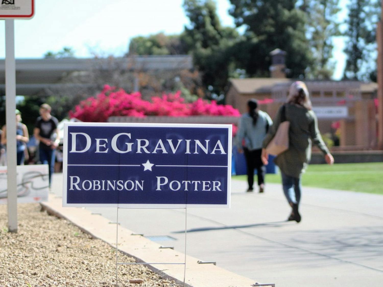 Students walk past a DeGravina campaign sign next to Hayden Lawn on the Tempe campus on March 16, 2017.&nbsp;