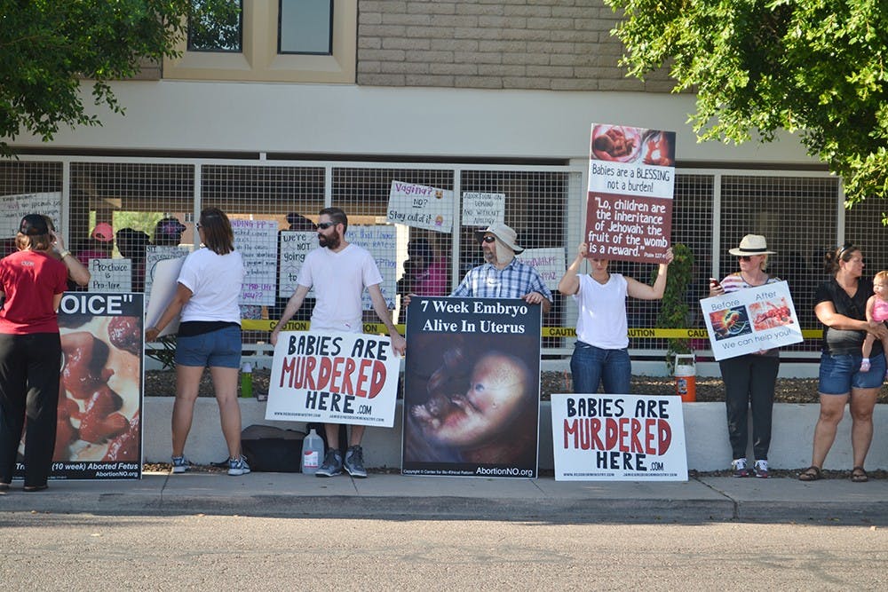 Protesters stand outside Planned Parenthood in downtown Phoenix on Saturday, Aug. 22, 2015.