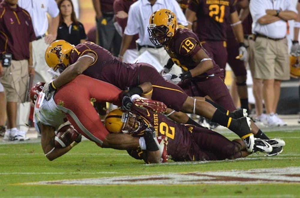 WRAPPING UP: Sophomore linebacker Vontaze Burfict and junior safety Eddie Elder take down a player from Washington State during ASU’s shutout victory over the Cougars on Saturday. Next up for the Sun Devils defense is the USC offense, ranked 13th in the nation. (Photo by Aaron Lavinsky)