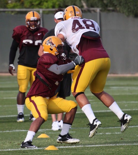 Ball Hawk: ASU junior linebacker Vontaze Burfict brings down redshirt freshman linebacker Carl Bradford during spring practice on March 29 in Tempe. The Sun Devil defense dominated Saturday’s scrimmage while the offense played without three key receivers. (Photo by Beth Easterbrook)