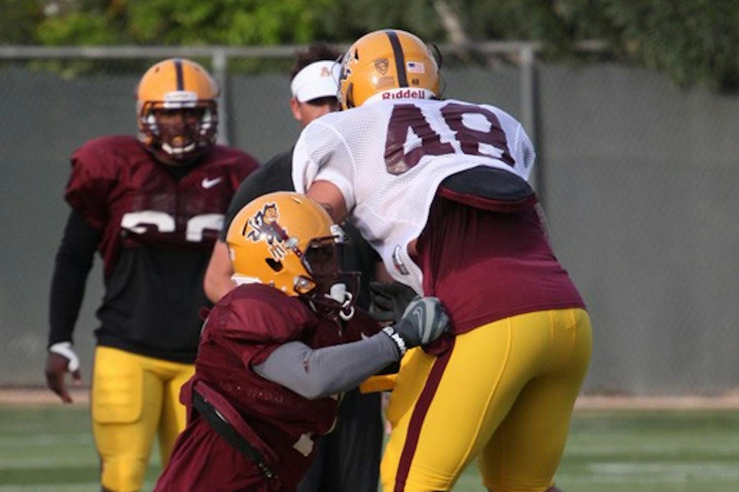 Ball Hawk: ASU junior linebacker Vontaze Burfict brings down redshirt freshman linebacker Carl Bradford during spring practice on March 29 in Tempe. The Sun Devil defense dominated Saturday’s scrimmage while the offense played without three key receivers. (Photo by Beth Easterbrook)
