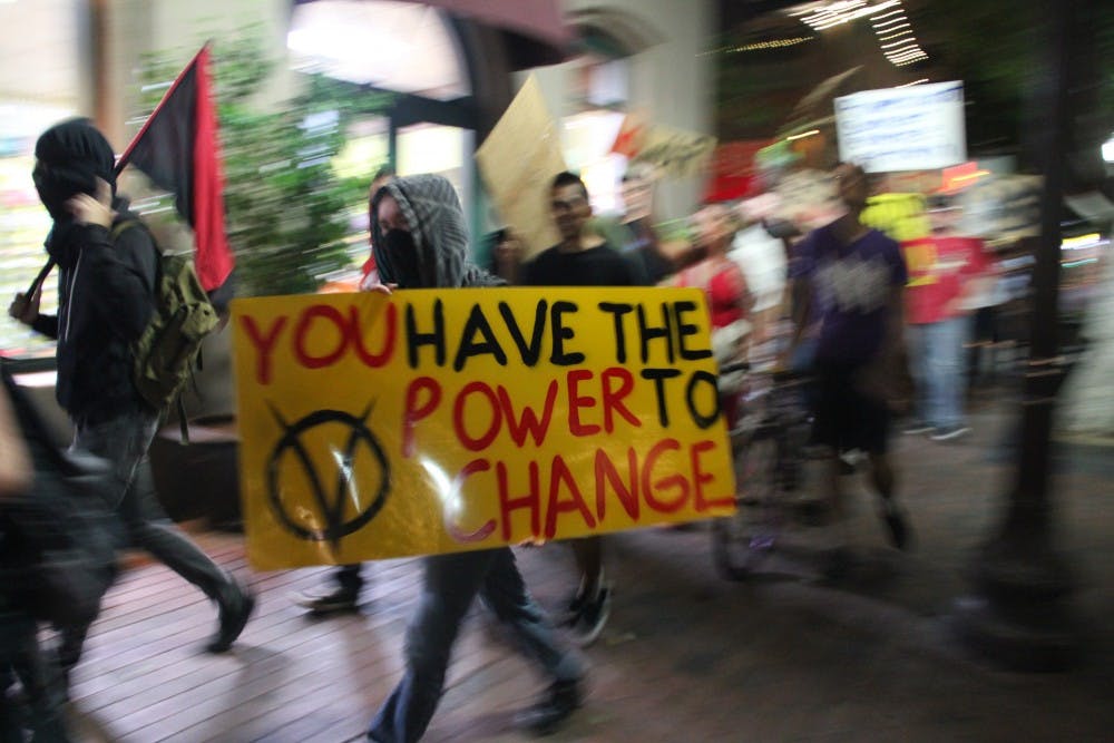 Protesters march on Mill Avenue on Saturday. The group met at Tempe Beach Park and marched through downtown Tempe. (Photo by Diana Lustig)