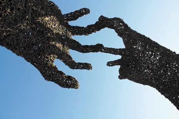 The statue of two hands at the light rail station near Terrace Road and Apache Boulevard in Tempe reach toward a blue winter sky. (Photo by Jenn Allen)