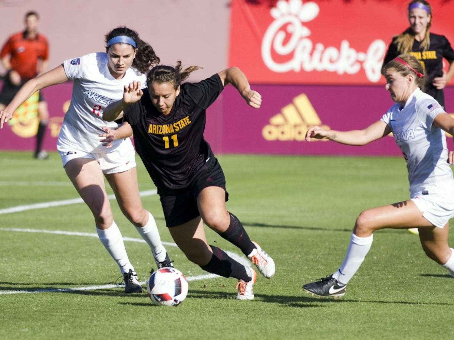 ASU freshman forward Olivia Hernandez (11) fights off two Wildcat defenders to try and get a shot off in the first half of a game versus the Arizona Wildcats in Sun Devil Soccer Stadium in Tempe, Arizona, on Friday, Nov. 4, 2016. 