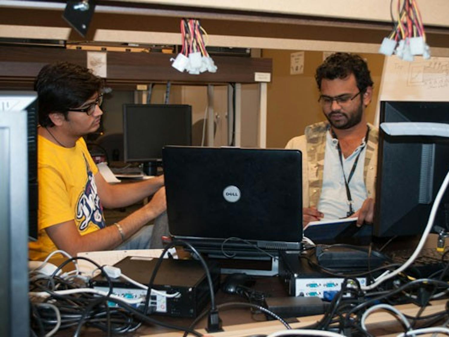 Imtiyaz Hussain and Koshik Samoth, both computer science graduate students, work on a group project in the engineering lab of the Ira A. Fulton Schools of Engineering on the Tempe campus on Sunday afternoon. The engineering program is currently focusing on getting their first-year students more experience to better prepare them for the work force after graduation. (Photo by Danielle Gregory)