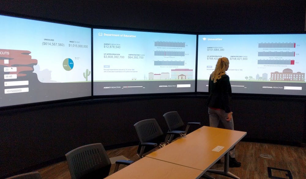 Emily Herring, a student-worker at the Decision Theater, walks past display screens on Sept. 23, 2016.&nbsp;