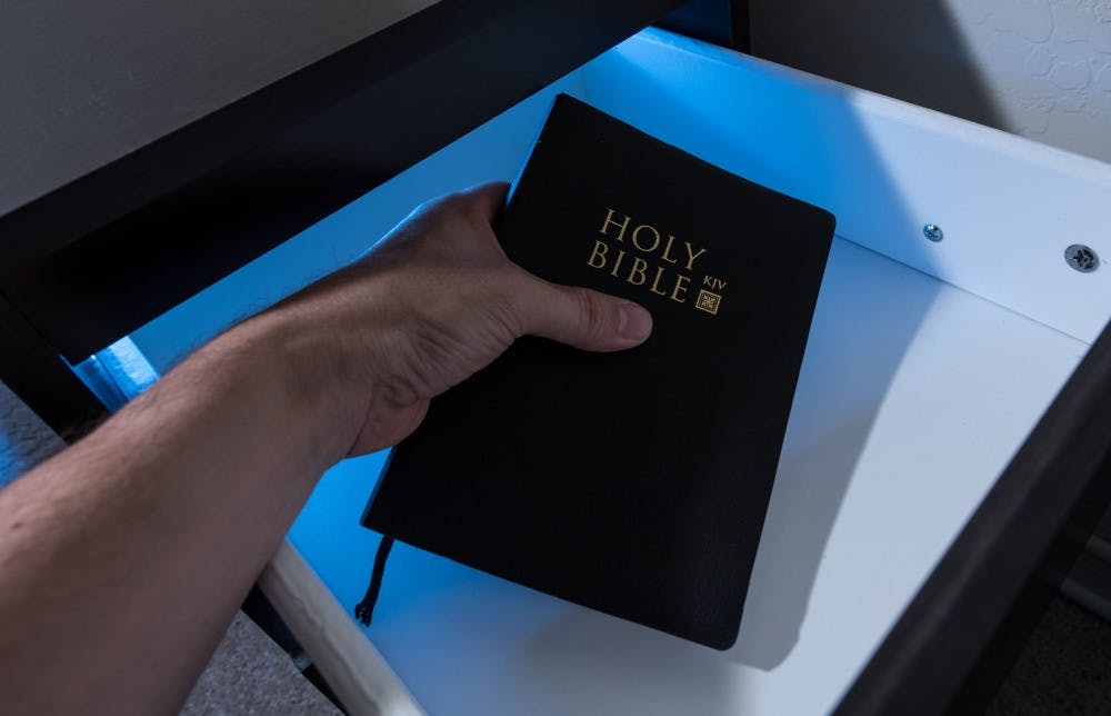 A bible is removed from a nightstand  in this photo illustration on Monday, Sept. 12, 2016. The Thunderbird Executive Inn no longer provides bibles in guests’ rooms after a complaint was made from the Freedom From Religion Group.