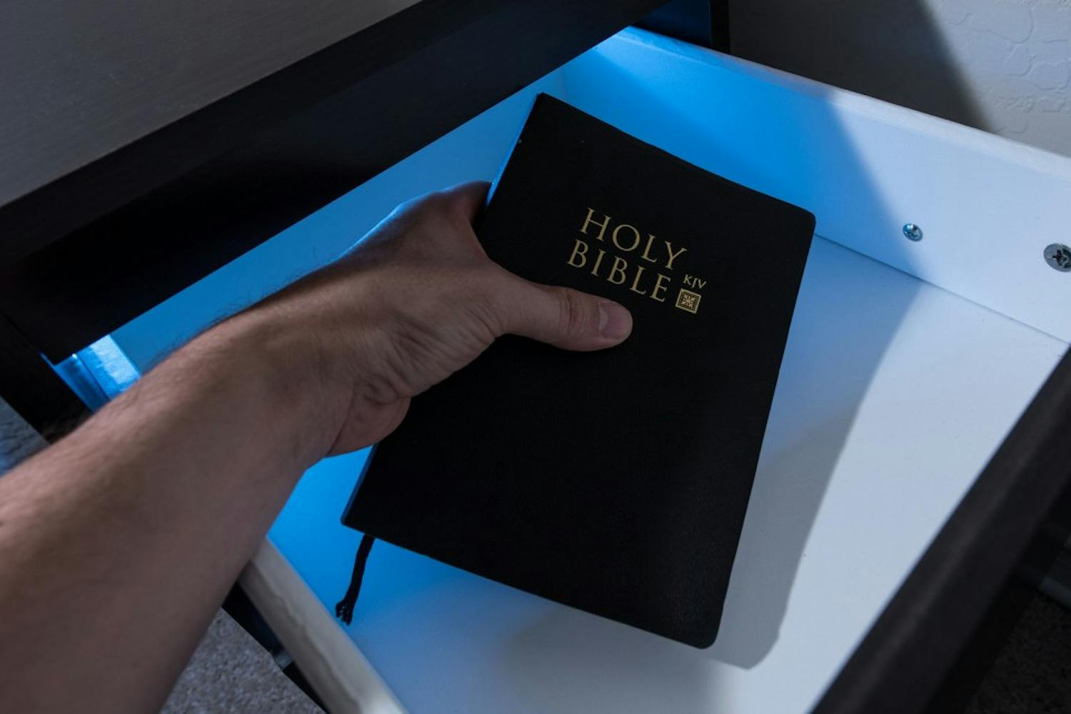 A bible is removed from a nightstand  in this photo illustration on Monday, Sept. 12, 2016. The Thunderbird Executive Inn no longer provides bibles in guests’ rooms after a complaint was made from the Freedom From Religion Group.
