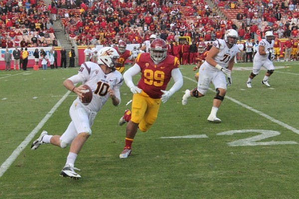 Redshirt sophomore quarterback Taylor Kelly scrambles from USC redshirt freshman defensive tackle Antwaun Woods in ASU’s 38-17 loss to the Trojans on Saturday. (Photo by Edmund Hubbard)