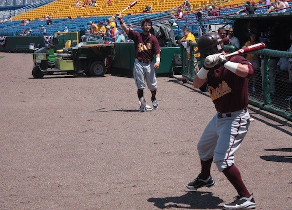 Freshman Andrew Aplin (no helmet) and senior Kole Calhoun prepare for their team's elimination game against South Carolina. (Photo by Nick Kosmider)