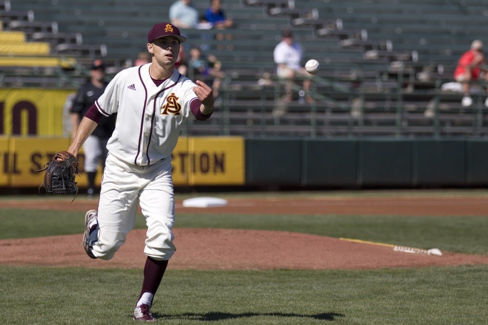 ASU sophomore starting pitcher Zach Dixon (6) tosses the ball to first base after a Cowboys batter hit it in front of the mound during a baseball game versus the Oklahoma State Cowboys at Phoenix Municipal Stadium in Phoenix on Tuesday, Feb. 21, 2017. ASU lost the game 18-4. (Josh Orcutt/State Press)