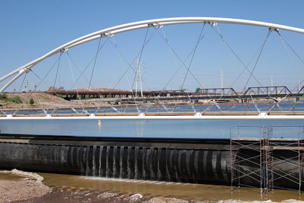 OUT WITH THE OLD:  Water cascades over the inflatable rubber dam at the west end of Tempe Town Lake.  The city chose to replace the rubber dams with a more permanent option. (Photo by Lisa Bartoli)