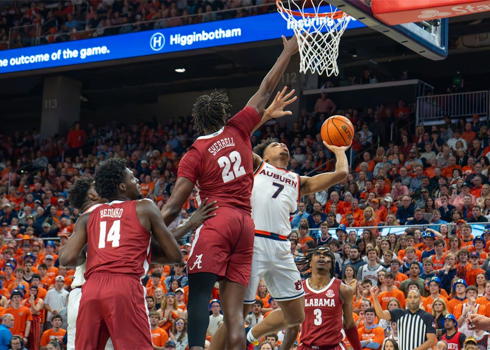 Auburn guard drives toward the basket for a layup as two Alabama defenders contest the shot during last season’s Iron Bowl at Auburn.
